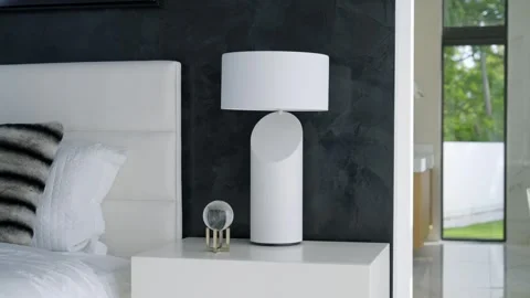Comfortable bedroom with focus on bedside table and cylindrical lamp. Clean Stock Footage 275677118