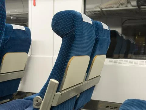 Comfortable blue patterned fabric seats arranged in a row inside a modern t.. Stock Photos