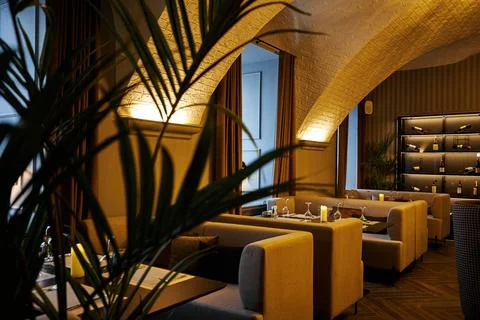 Comfortable cabins with sofas in semi-dark restaurant Stock Photos