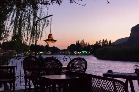 Comfortable cafe in bridge over the river at sunset Stock Photos