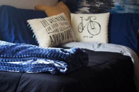 Comfortable decor bedding sheets pillows and throw blanket in bedroom Stock Photos