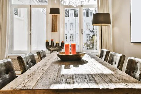 Comfortable dining room with a solid wooden table and candles on it Stock Photos