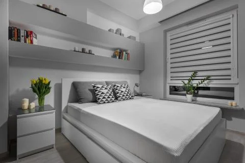 Comfortable double bed in modern and simple grey bedroom Stock Photos