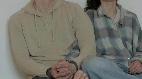 Comfortable duo sitting with clasped hands and casual attire Stock Footage 325531217