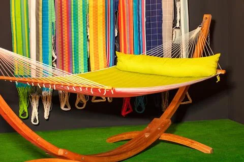 A comfortable fabric hammock is stretched on a massive wooden base. Stock Photos