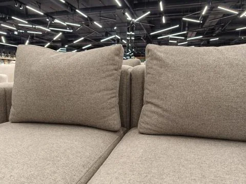 A comfortable gray sofa with large, soft cushions, for sale in a furniture .. Stock Photos