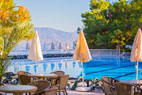 Comfortable high-rise hotel. Empty hotel, swimming pool, sea, palm trees, umb Stock Photos