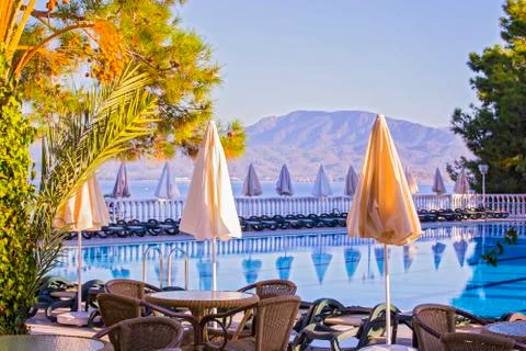 Comfortable high-rise hotel. Empty hotel, swimming pool, sea, palm trees, umb Stock Photos