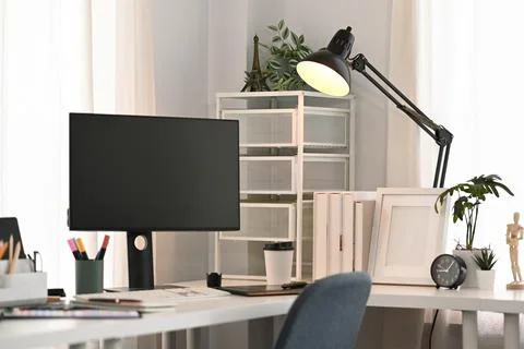 Comfortable home office. Computer with empty display, stationery, houseplant and Stock Photos