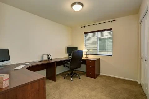 Comfortable home office interior with large brown desk and laptops. Stock Photos