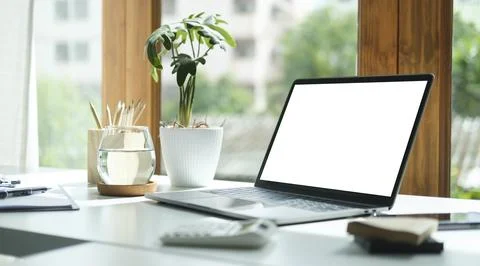 Comfortable home office. Laptop computer, stationery and potted plant on wh.. Foto stock