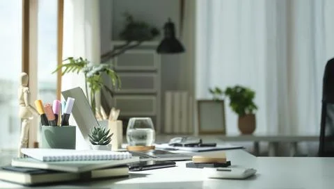 Comfortable home office with laptop computer, houseplant and supplies. Stock Photos
