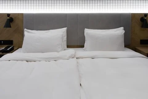A comfortable king size bed in a clean hotel room with plush pillows and Stock Photos