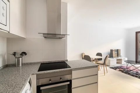 Comfortable kitchen island suite overlooking the living room with dining table Stock Photos