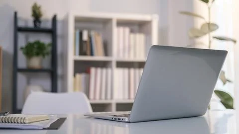 Comfortable office desk with laptop computer and notepad on white table. Stock-Fotos