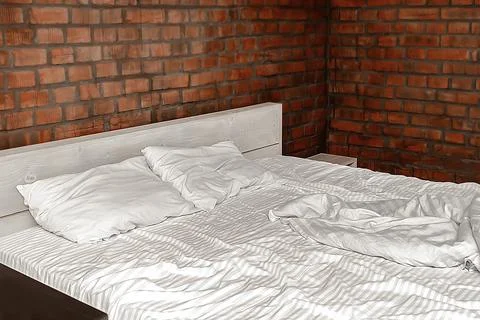 Comfortable rumpled messy crumpled bed white cotton sheets,duvet,blanket and 스톡 사진