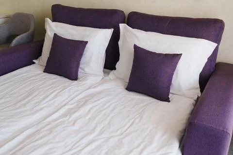 Comfortable sofa bed with pillows in a simple living space Foto stock