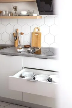 Comfortable white gray kitchen interior open box full of various crockery Stock-Fotos