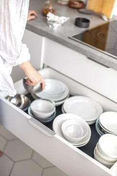 Comfortable white gray kitchen interior open box full of various crockery Stock Photos