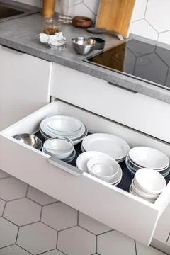 Comfortable white gray kitchen interior open box full of various crockery Stock Photos