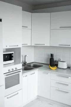 Comfortable white kitchen with a white lacquered facades. Modern kitchen clean Stock Photos