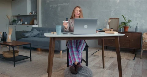 Comfortable work from home on lockdown. Young cheerful business woman in pajamas Stock-Footage 129128409