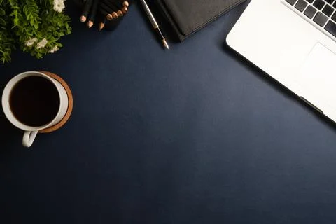 Comfortable work table with laptop, stationery and coffee cup. Top view wit.. Foto stock