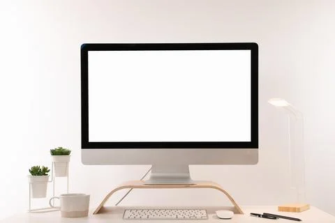 Comfortable workplace with blank computer display on desk against white backg Stock Photos