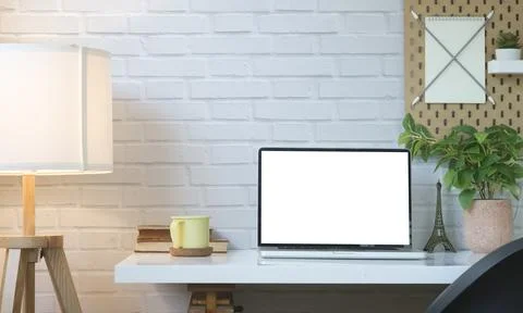 Comfortable workplace with laptop computer, coffee cup, books, houseplant a.. Stock Photos