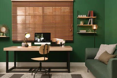 Comfortable workplace with modern computer near window in room. Interior desi Stock Photos