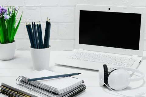 Comfortable workplace office - work table with blank white laptop headphones Stock Photos