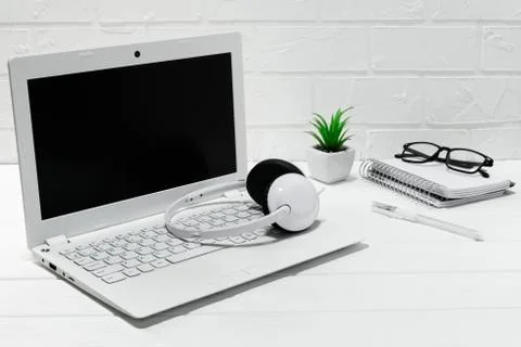 Comfortable workplace office - work table with blank white laptop headphones Stock Photos