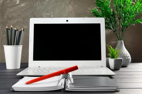 Comfortable workplace office work table with blank laptop and notebook - home Stock Photos