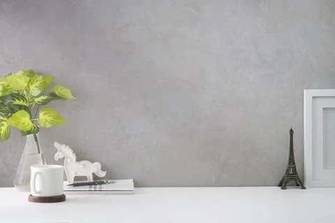 Comfortable workplace with picture frame, coffee, stationery and houseplant o Stock-Fotos