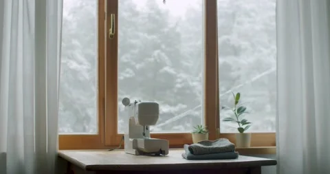 Comfortable workplace of seamstress by window winter landscape slow motion Stock Footage 146462205