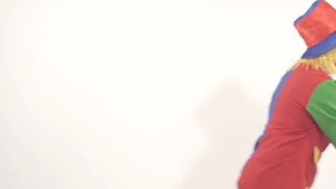 Comic clown going backward holding bright box Stock-Footage 70497888