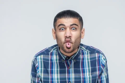 Comic faces concept. Funny hipster showing stupid face and looking at camera. Stock Photos