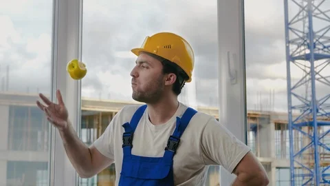 Comic fail. Builder drops the apple and pics it up. Vídeos de archivo 116564198