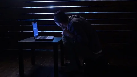 Comic funny hacker commits a cyber attack with a laptop and a gun in his hands Video stock 82556914