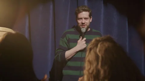 Comic Performing Stand Up Comedy Routine on Stage in front of Laughing Audience Stock Footage 333227528