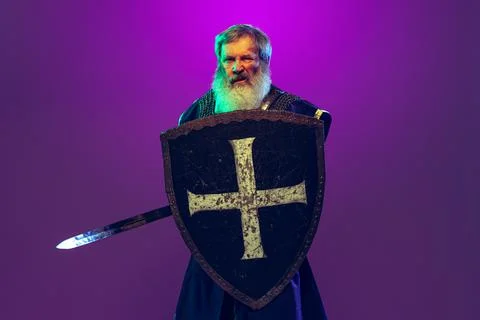 Comic portrait of senior grey-bearded man in image of medieval warrior or knight Stock Photos