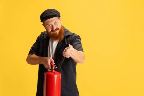 Comic portrait of stylish red-bearded man, barber in black cap having fun Stock Photos