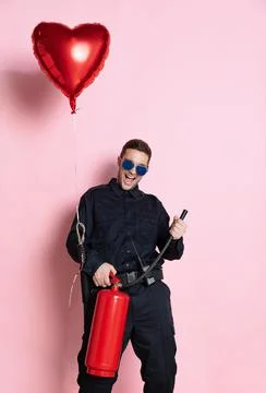 Comic portrait of young charming policeman officer having fun with heart shape Stock Photos