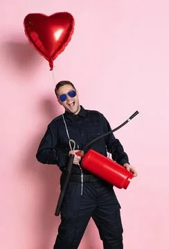 Comic portrait of young charming policeman officer having fun with heart shape Stock Photos