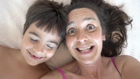 Comic selfie of mother shouting in ear of her son Stock Footage 158592664