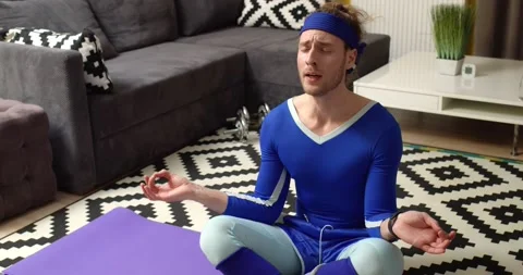 Comical Caucasian Man calms down practicing Yoga breathing in Lotus Pose Stock-Footage 153682209