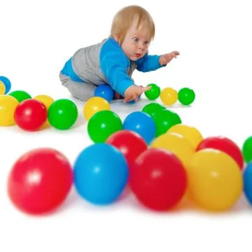 Comical child playing with colored plastic balls Stock Photos
