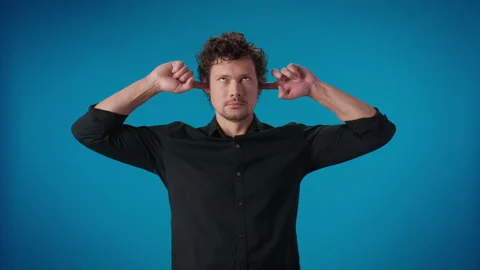 Comical curly man fooling closed ears fingers don't want listening squeamish Stock Footage 172527317
