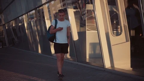 Coming from abroad nice guy in white T-shirt and shorts waking in the street and Stock Footage 91150820