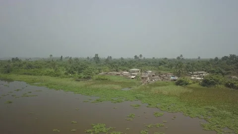 Coming inside and fly over village in the jungle on the side of lake africa Stock Footage 168033709
